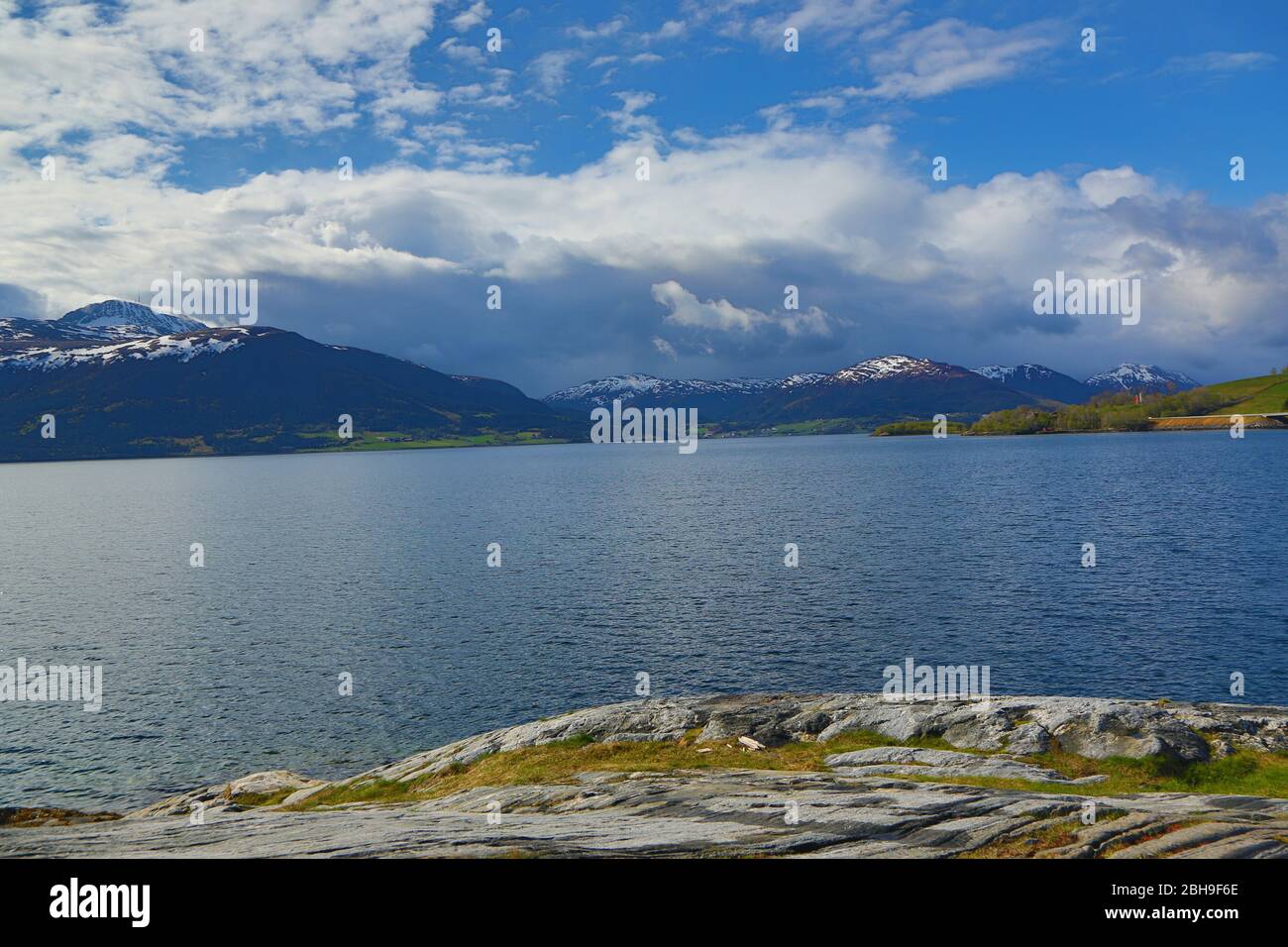 White clouds blue sky over blue fjord Stock Photo
