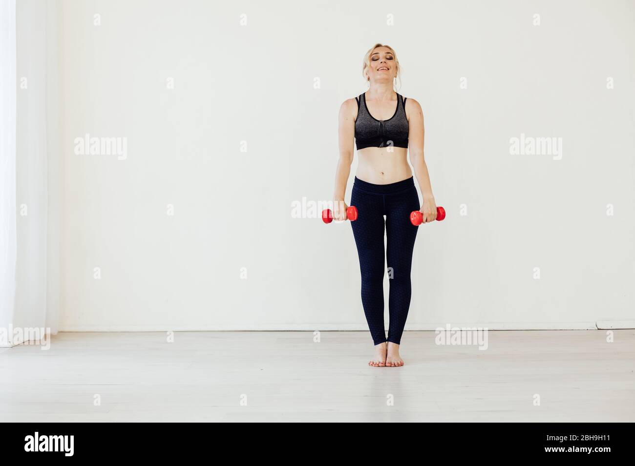Beautiful blonde woman sports with fitness dumbbells Stock Photo