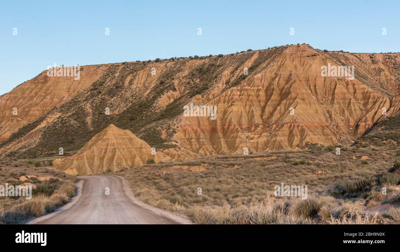 Roadtrip in winter through the semi-desert Bardenas Reales, Navarra, Spain. A UNESCO Biosphere Reserve with among others Castil de Tierra, Pisquerra Mountains and Bardena Blanca. Gravel road. Stock Photo