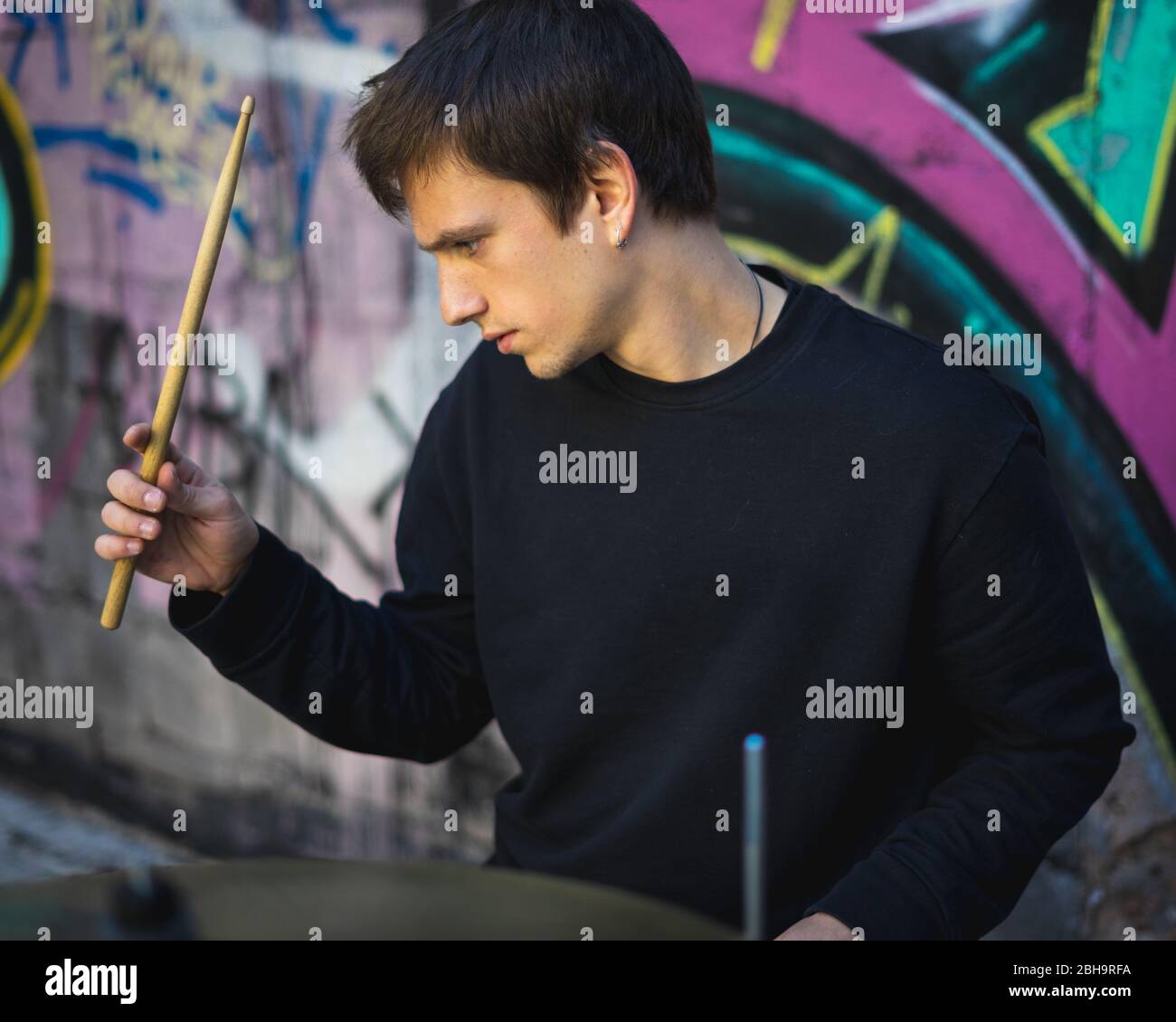 Young man playing drums in an underground environment Stock Photo