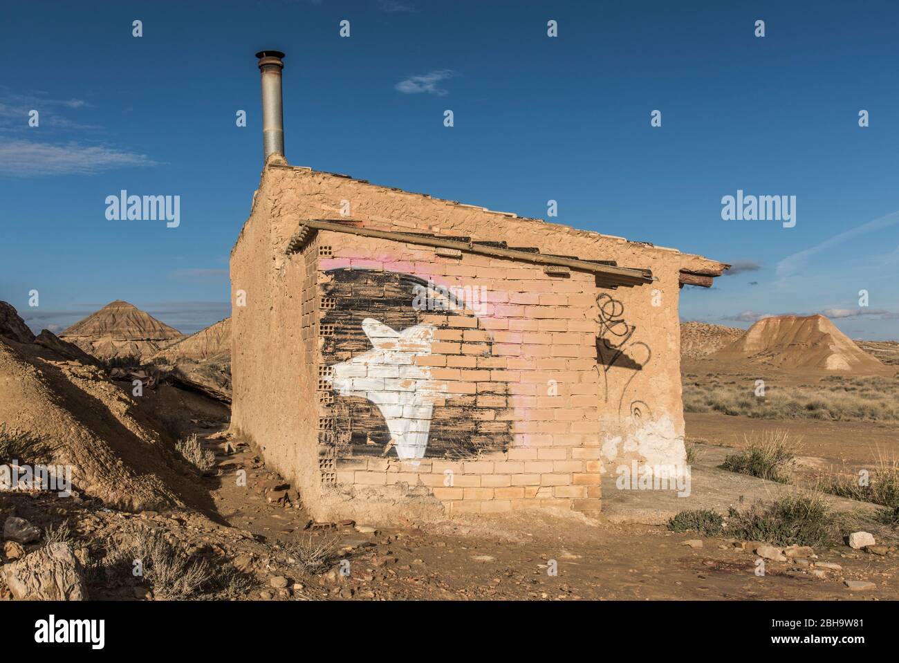 Roadtrip in winter through the semi-desert Bardenas Reales, Navarra, Spain. A UNESCO Biosphere Reserve with among others Castil de Tierra, Pisquerra Mountains and Bardena Blanca. Refuge for shepherd with grafitti. Stock Photo