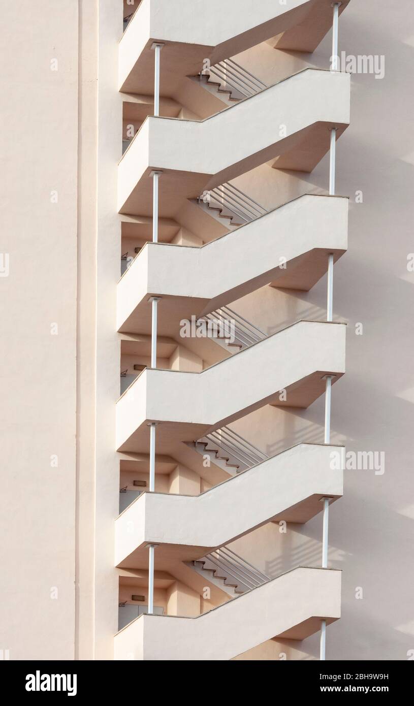Emergency staircase casting its shadow on a neutral-coloured facade. Abstract image Stock Photo