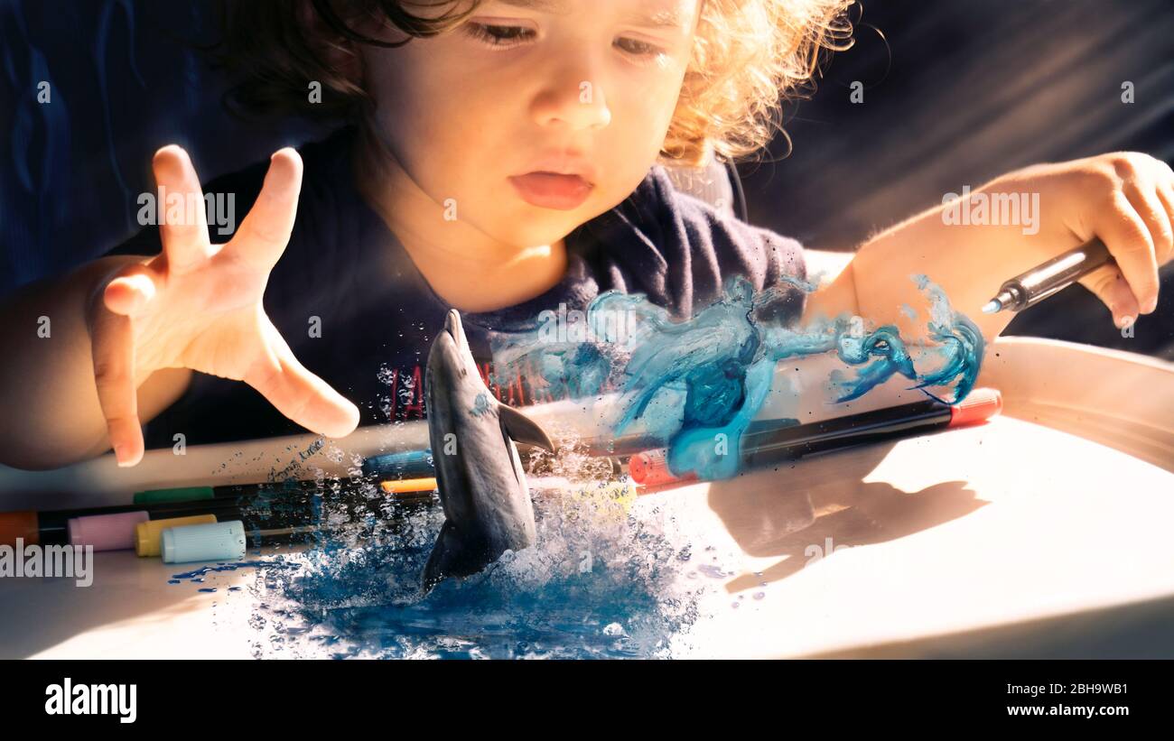 Concept of toddler imagination, dream painting a dolphin. Virtual reality or augmented reality study. Dreamy picture of kids imagination and fantasy Stock Photo