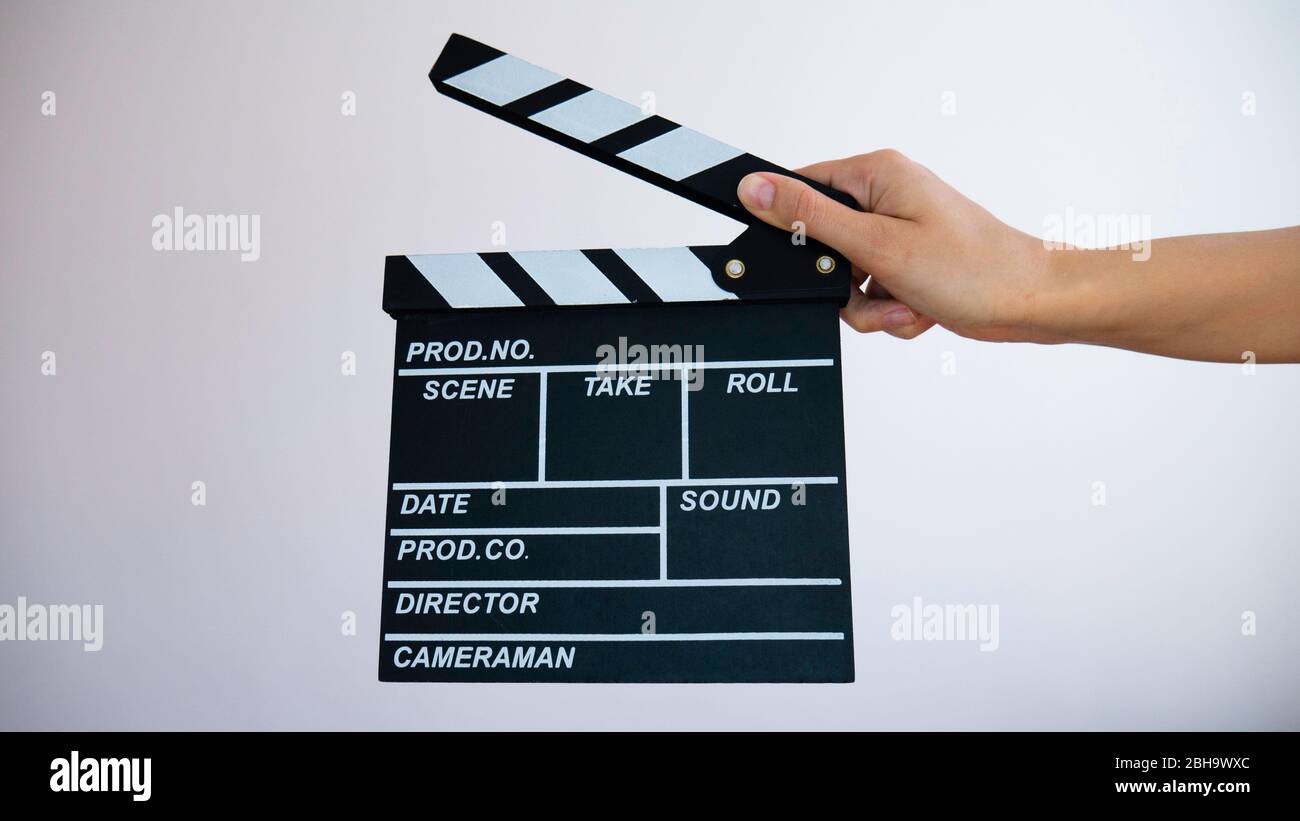 Hands holding clapperboard isolated on white background. Stock Photo