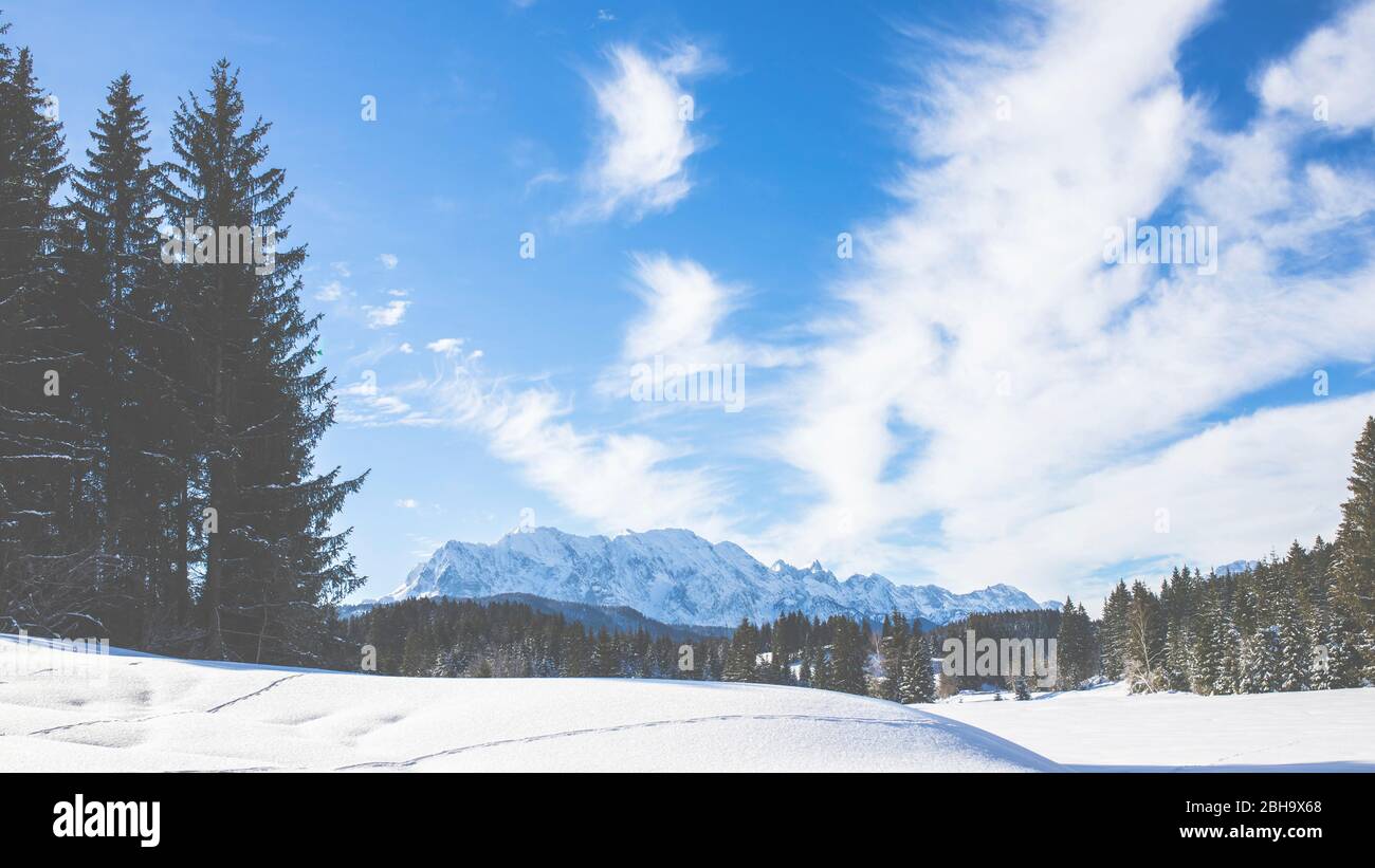 On Tennsee near Krün in winter with a view of the Wetterstein massif and the summits of the Alps near Landkreis Garmisch-Partenkirchen, Bavaria, Germany. Stock Photo