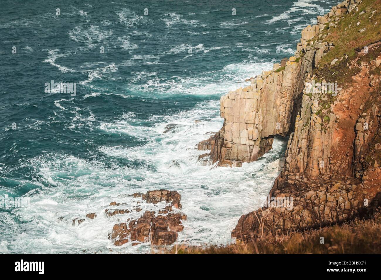 Wellen und Gischt am Fels, an der Küste bei Lands End, Penzance, Cornwall, England, Großbritannien Stock Photo