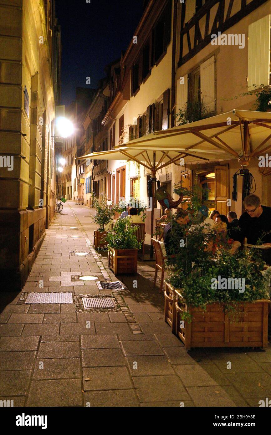 France, Alsace, Strasbourg, old town, narrow lane, pedestrian area, street restaurant, guests, in the evening Stock Photo