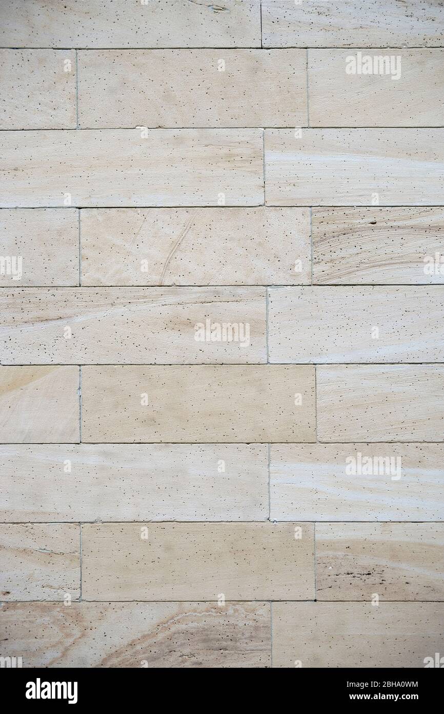 A light beige cladding made of marbled sandstone with pores. Stock Photo