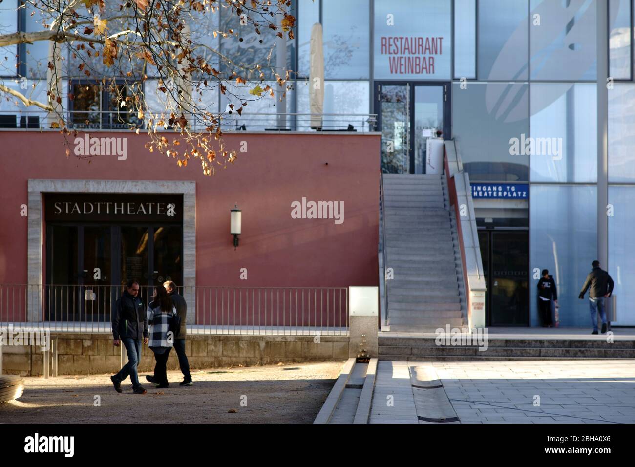 Aschaffenburg, Germany, pedestrians and children in front of the modern glass facade of the city theater Aschaffenburg with entrance to a wine bar and a restaurant Stock Photo