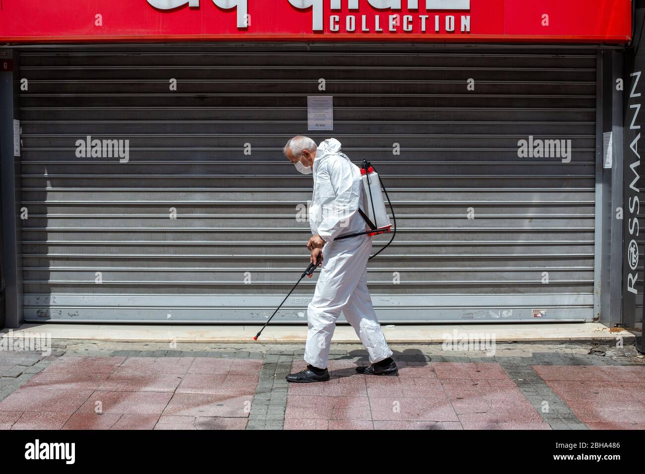 April 22, 2020, Istanbul, Turkey:A municipal official who disinfects the sidewalks at Bakirkoy streets before four days curfew during coronavirus day. Stock Photo