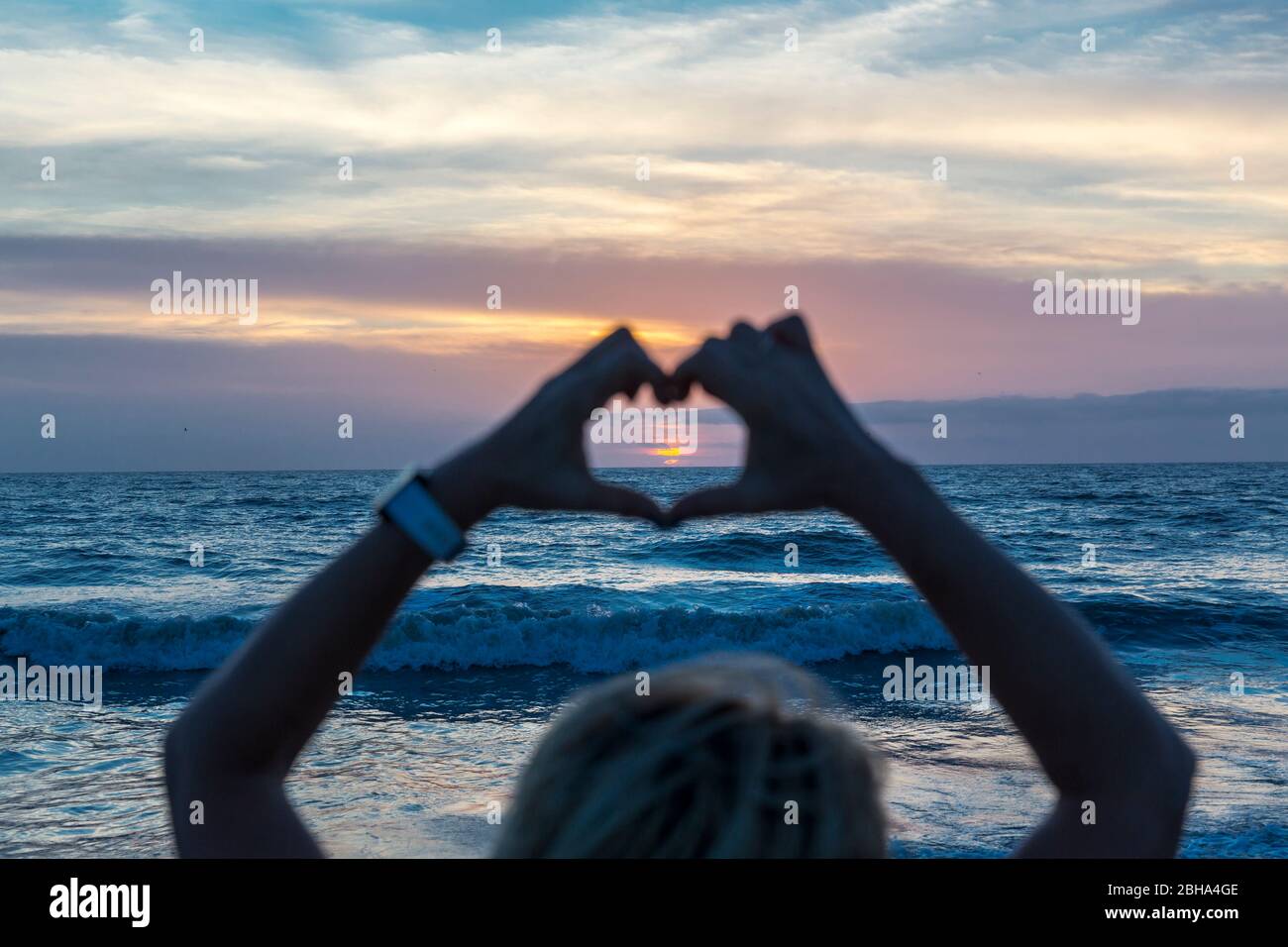 Frau formt Herz mit ihren Händen, Sonnenaufgang, Cocoa Beach, Florida, USA, Nordamerika Stock Photo