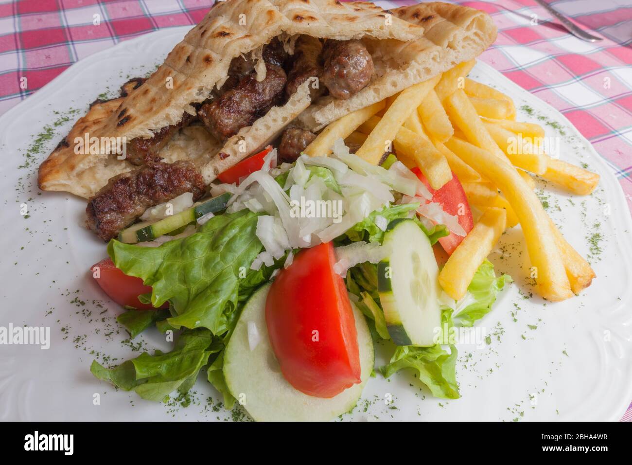 Europe, Bosnia and Erzegovina, Medjugorje. Cevapcici and vegetables. Popular food of Balkans Stock Photo
