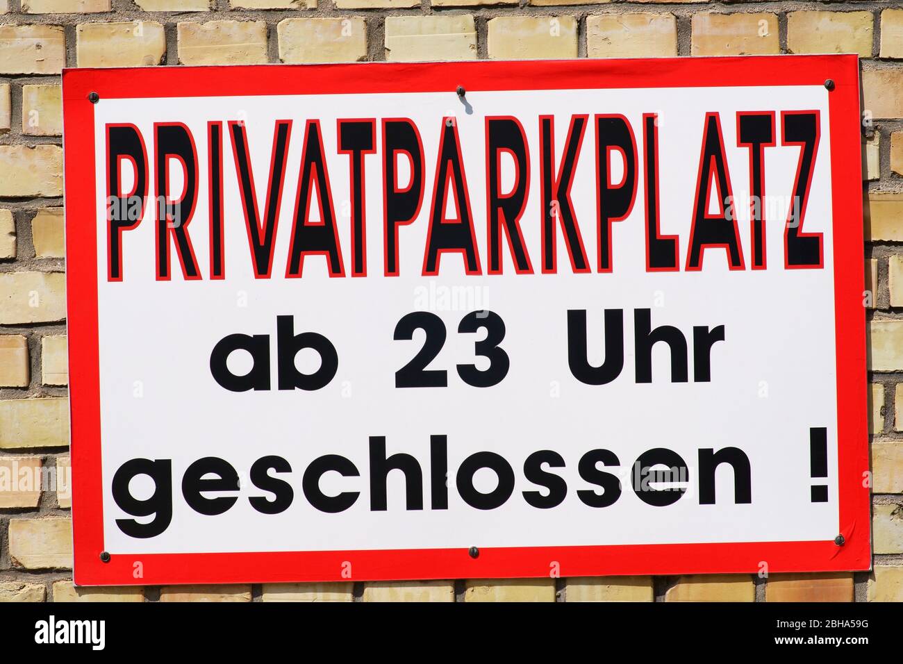 A striking red-framed sign with the words private parking on a bright clinker façade. Stock Photo