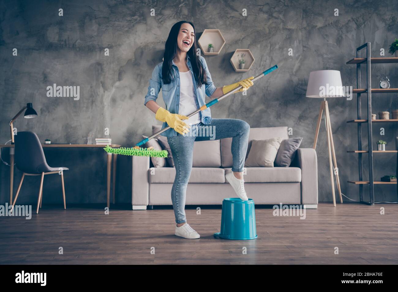 Yeah i am rock star. Full size photo of positive cheerful cool girl have  household chores hold mop imagine she perform song on stage wear denim  jeans Stock Photo - Alamy