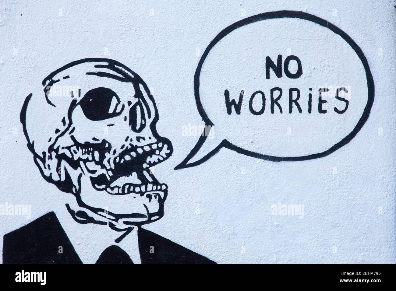 No Worries sign on a white wall cartoon with skeleton Stock Photo