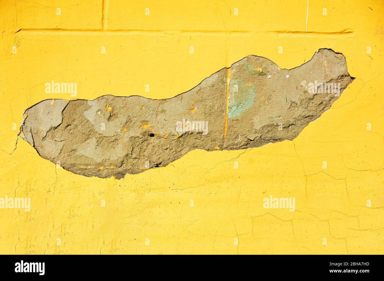 Yellow wall with scratches and chips. Abstract background. Stock Photo