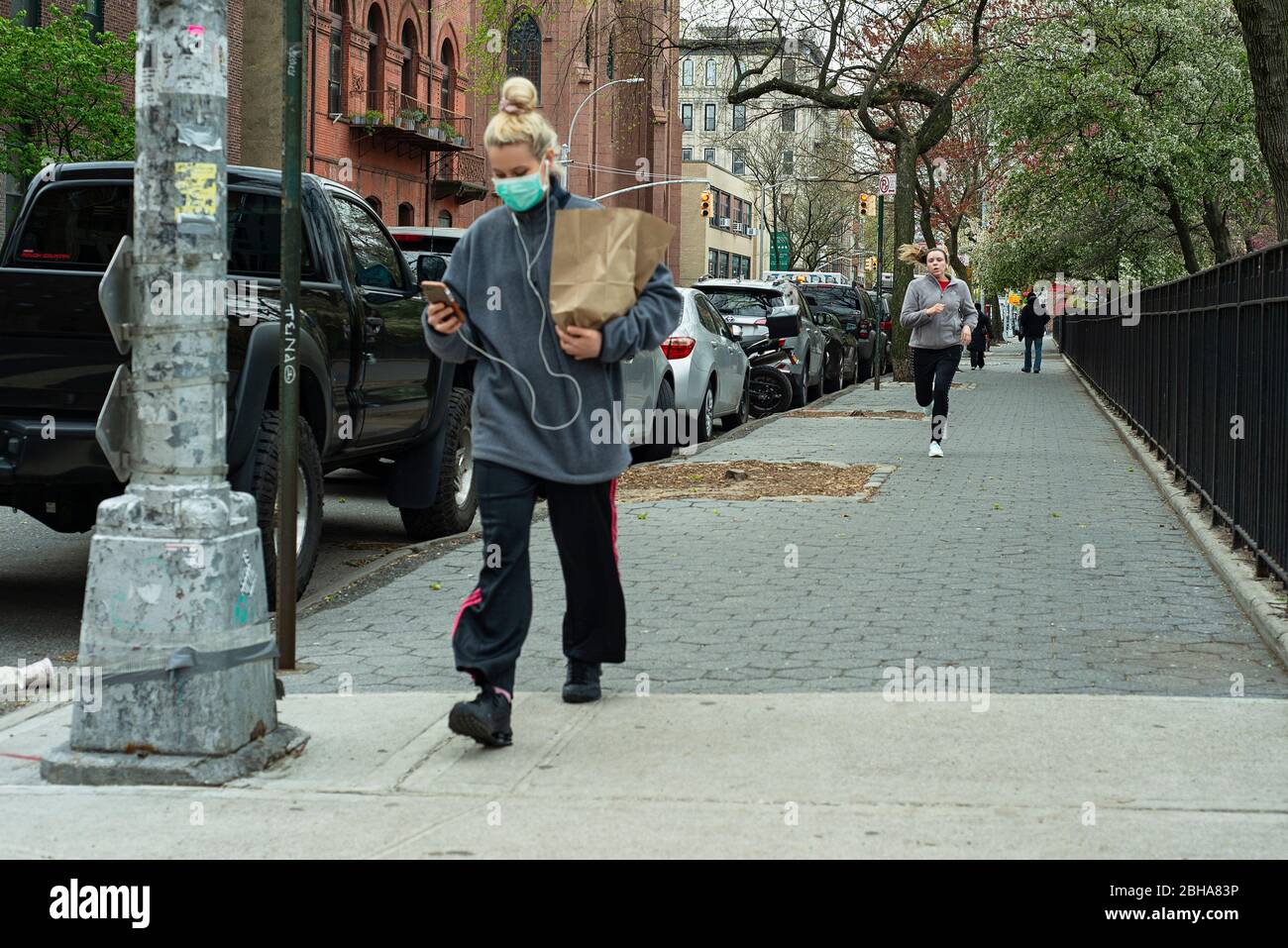 A runner approaching a pedestrian from behind in April 2020 during the COVID 19 pandemic in New York City. Stock Photo