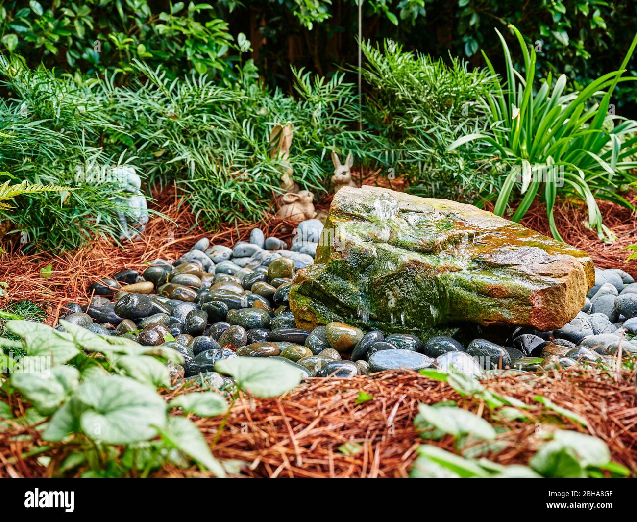 Rock water feature or fountain in a home or residential garden. Stock Photo