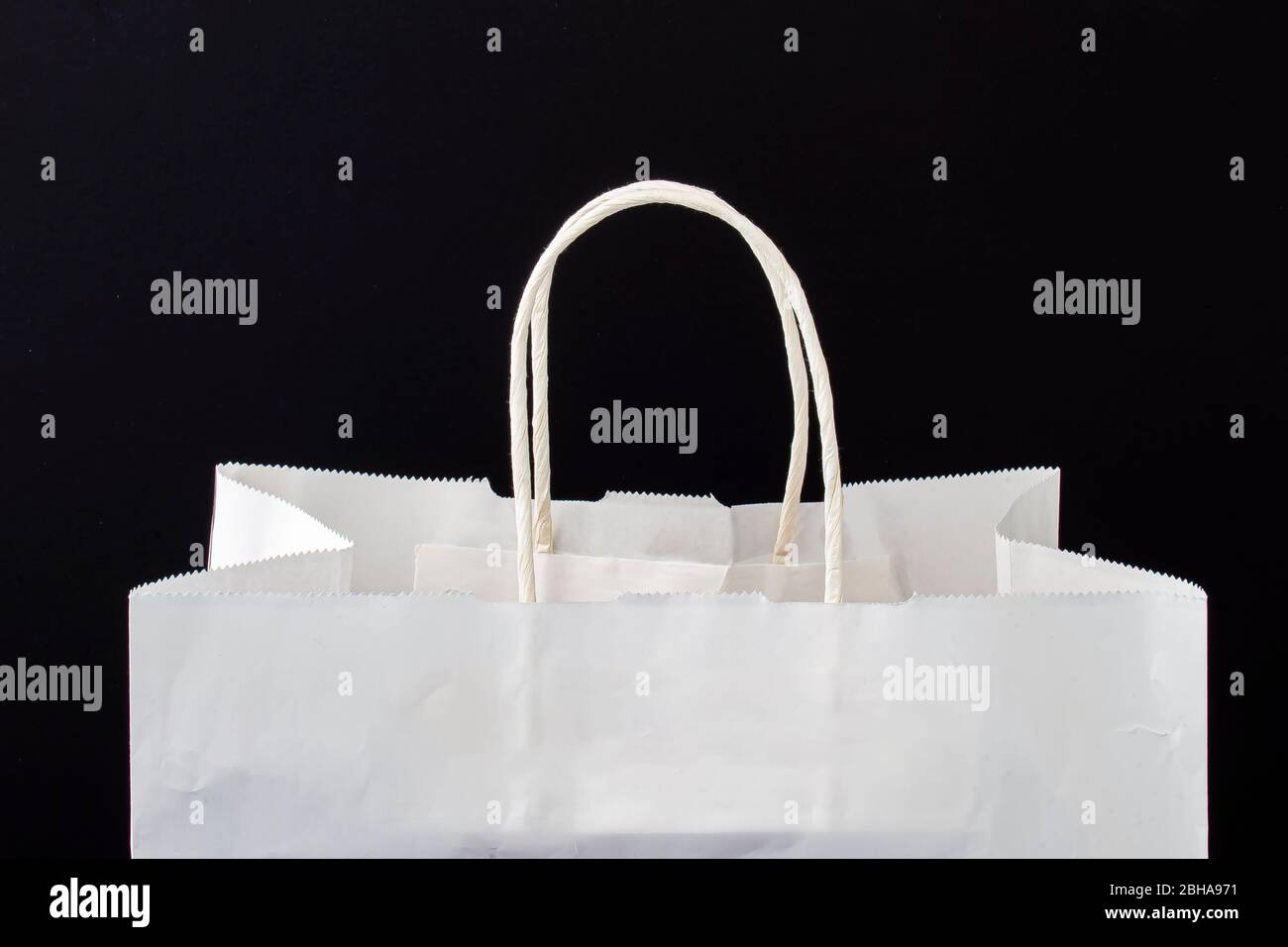 A white paper bag with holders on a black background Stock Photo