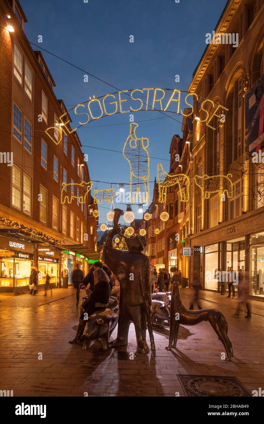Einkaufsstraße Sögestraße mit Skulptur 'Schweinehirt und seine Herde' und Weihnachtsbeleuchtung bei Abenddämmerung, Bremen, Deutschland, Europa Stock Photo