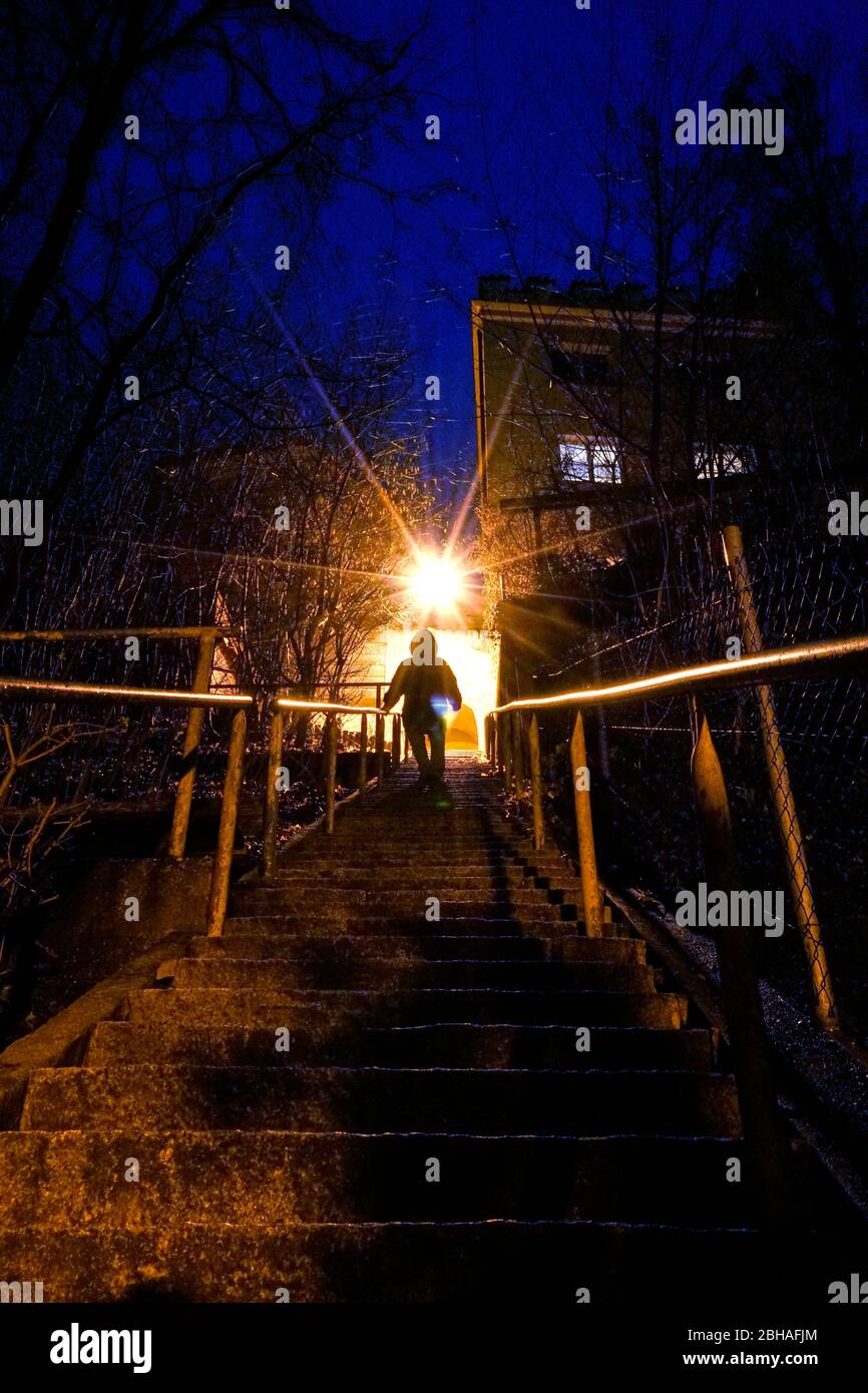 Deutschland, Bayern, Oberbayern, Landkreis Altötting, Neuötting, Steintreppe, Licht, abends, Mann, dunkle Gestalt kommt die Treppe runter Stock Photo