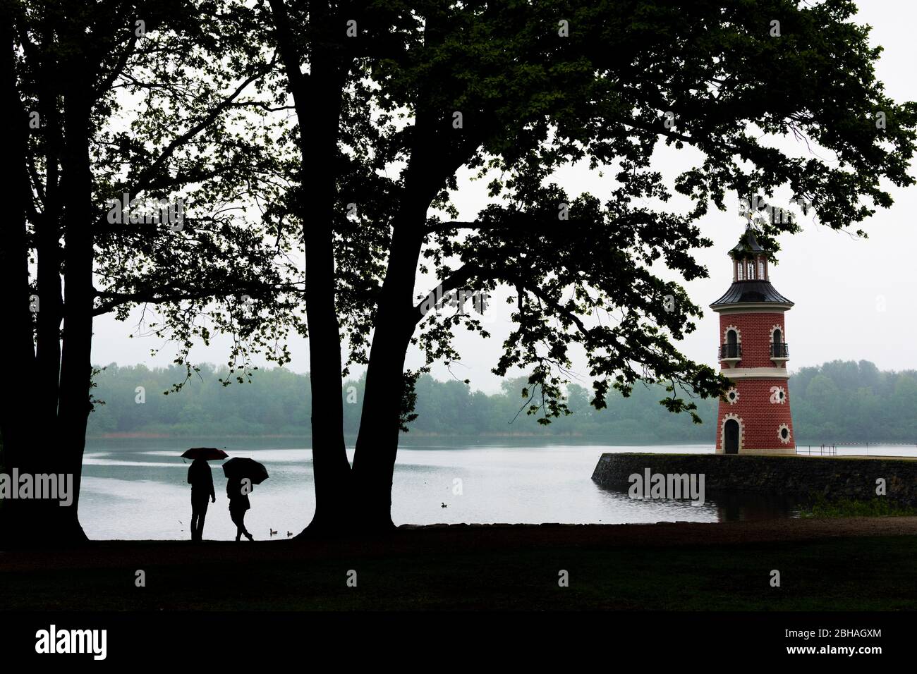 Moritzburg: Lighthouse with jetty at pond Großteich, rain, people with umbrella in, Sachsen, Saxony, Germany Stock Photo