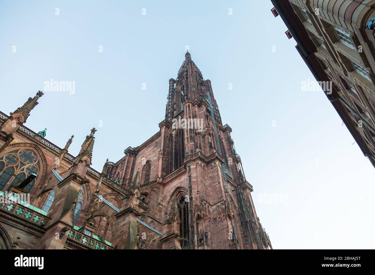 Ornate Gothic spire of Strasbourg Cathedral, Alsace, France viewed from below against a hazy sky Stock Photo