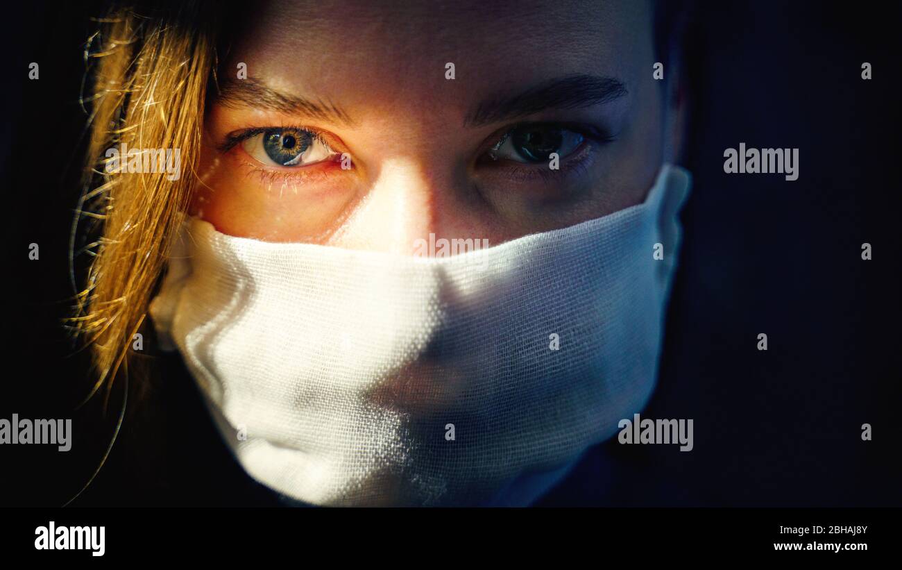 Eyes of a woman in a gauze mask looking at the camera close up