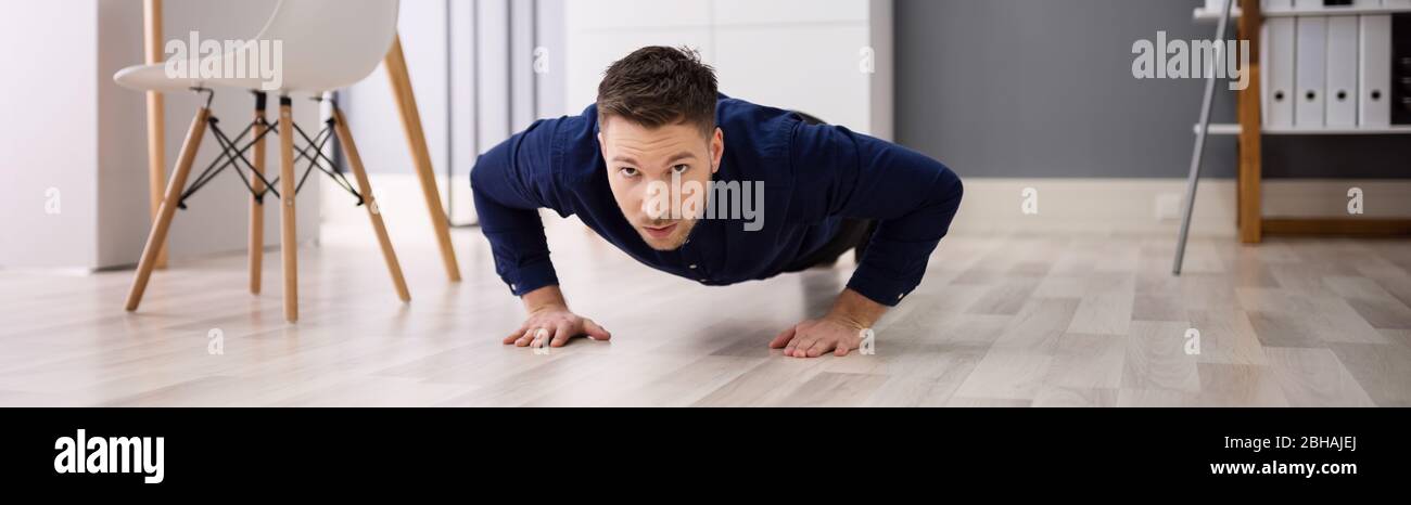 Office Workout Exercise. Healthy Man Doing Pushups Stock Photo