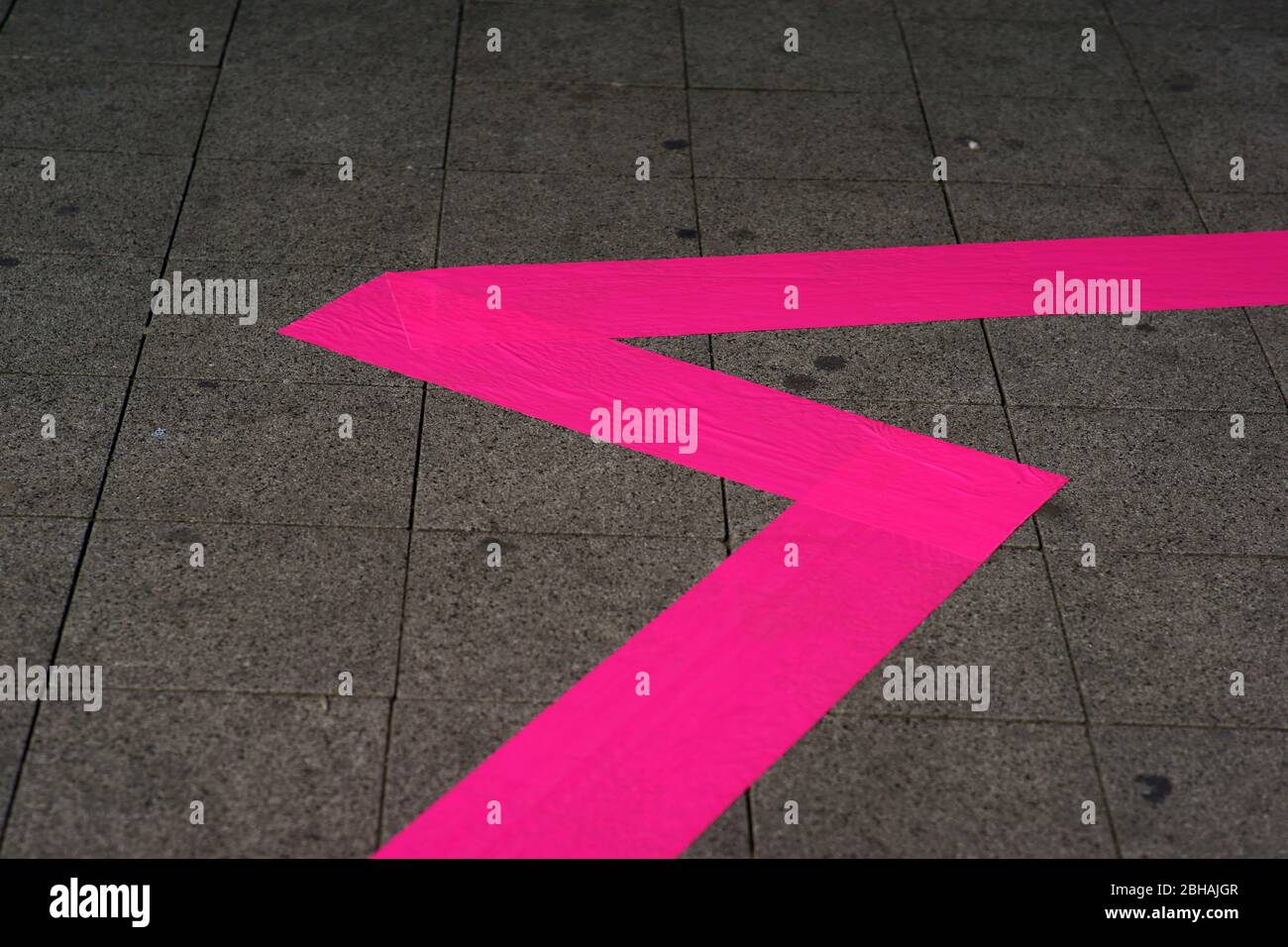 A neon flash sidewalk marker made from a wide strip of tape to isolate an event. Stock Photo