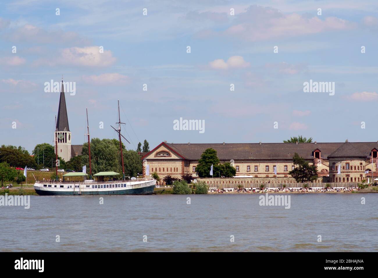 The banks and the promenade along the river Rhine in Mainz Kastel with the Kasteler beach and the beach boat and the St. George church in the background. Stock Photo