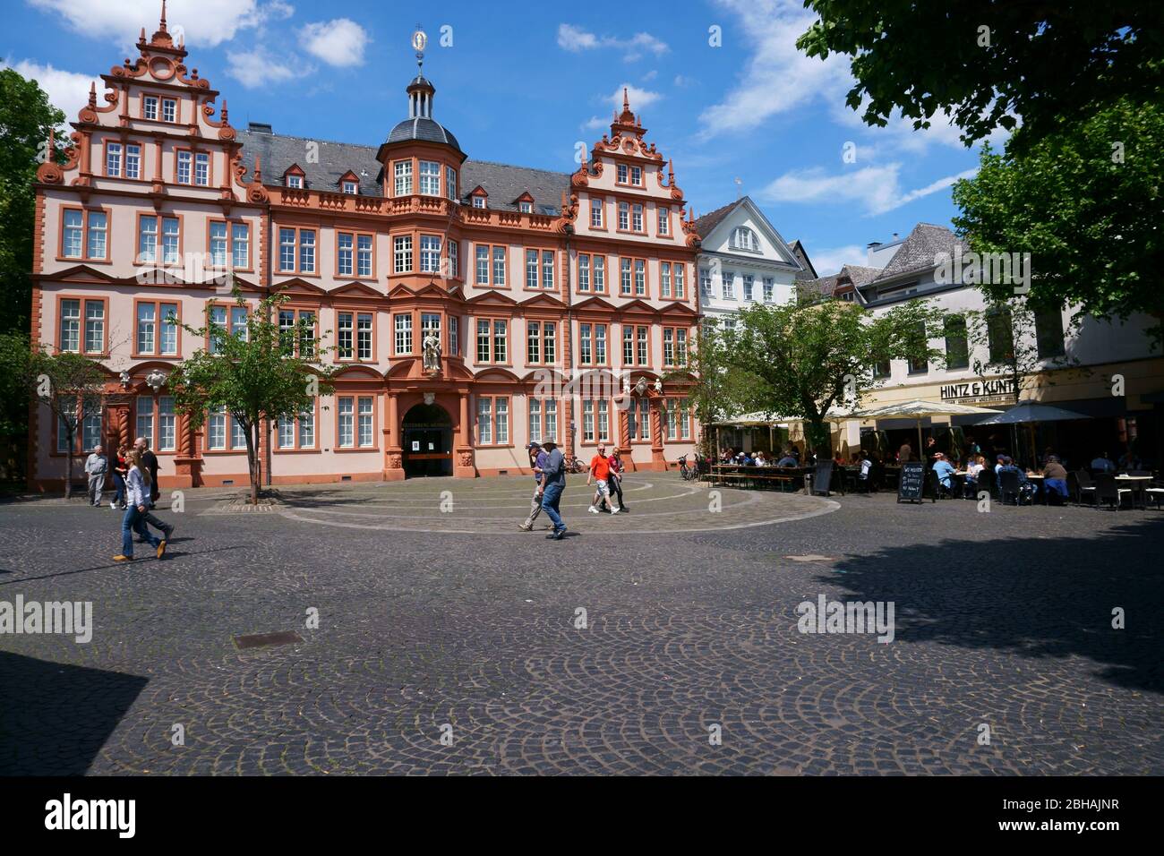 Pedestrians and passers-by as well as restaurant visitors of the Hintz and Kuntz in front of the Gutenberg Museum in Mainz. Stock Photo