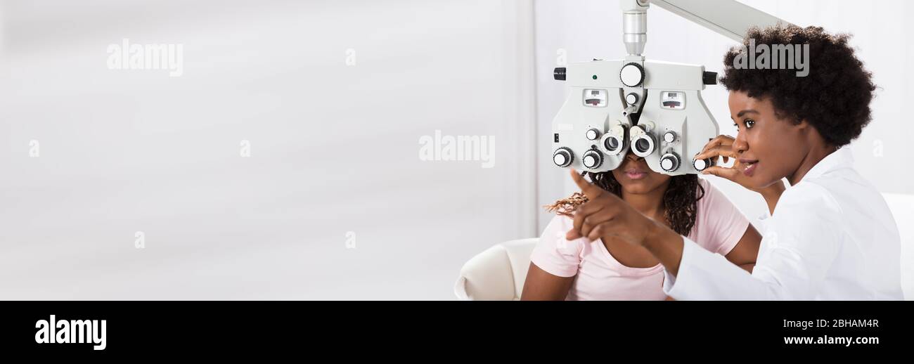 Optician Doing Optometry Eye Exam For Black African Patient Stock Photo