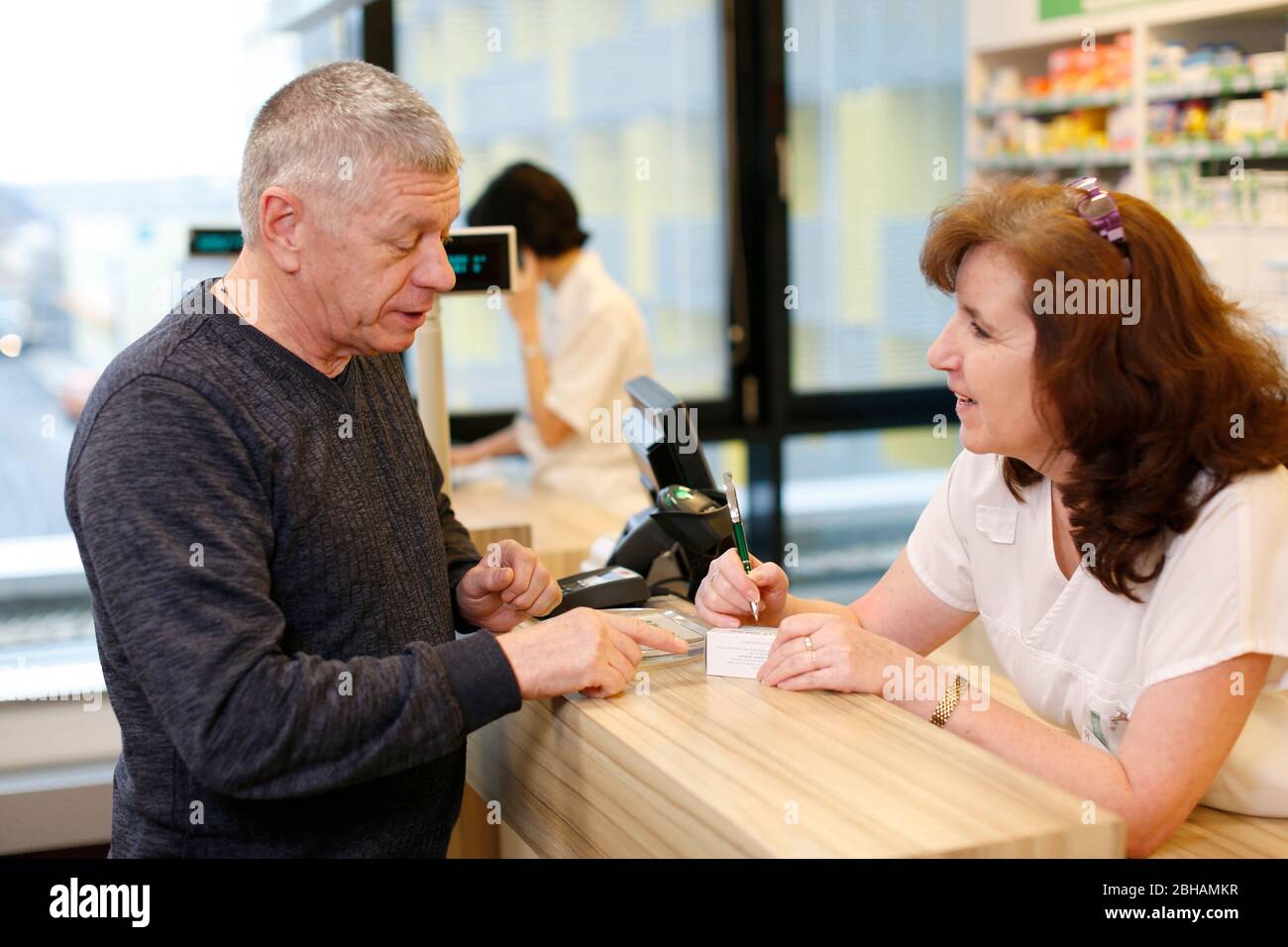 Customer in the pharmacy talks to a pharmacist Stock Photo