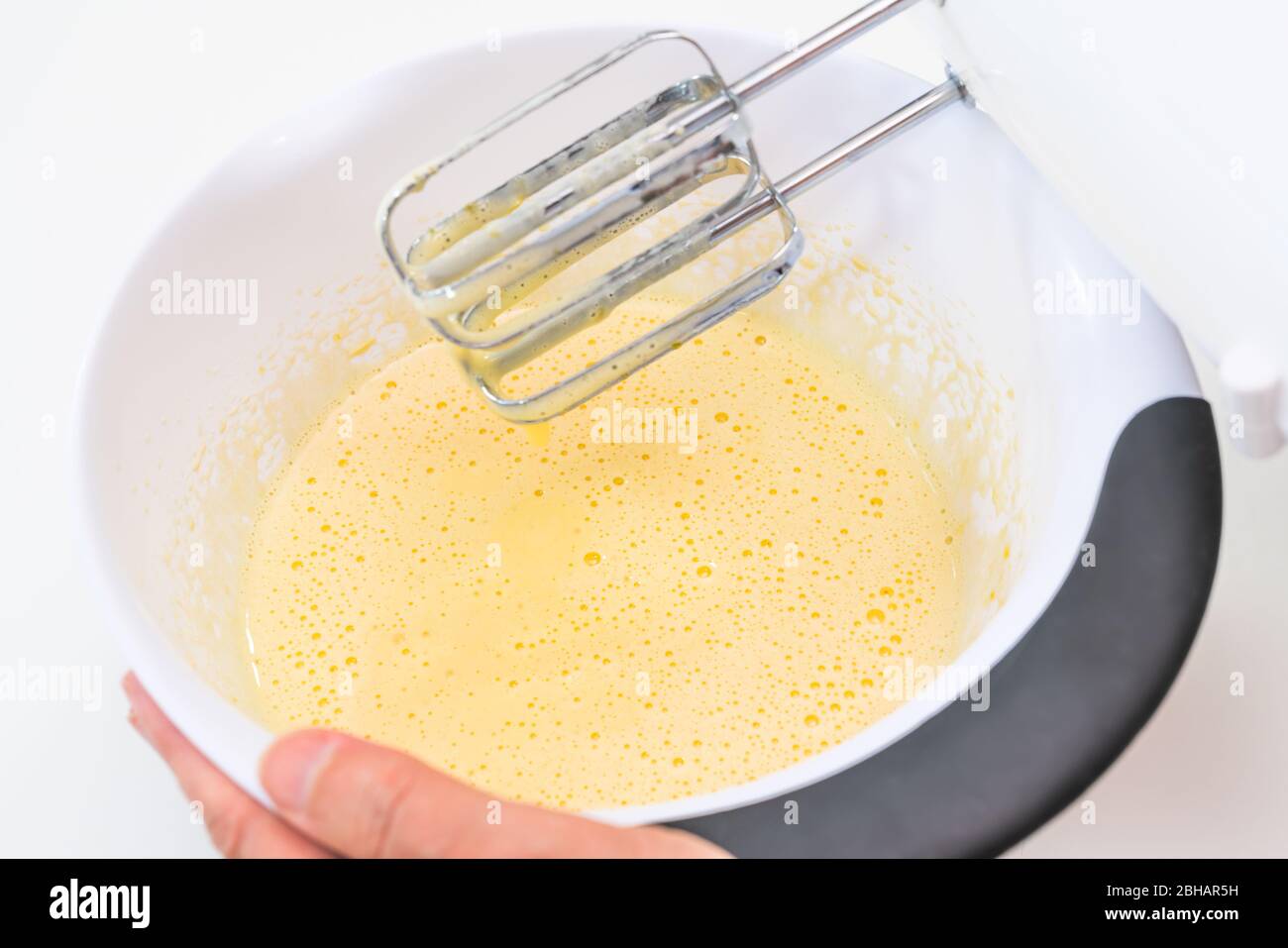 Mixing biscuit dough with an electic mixer. close up process. Cake batter making. Stock Photo