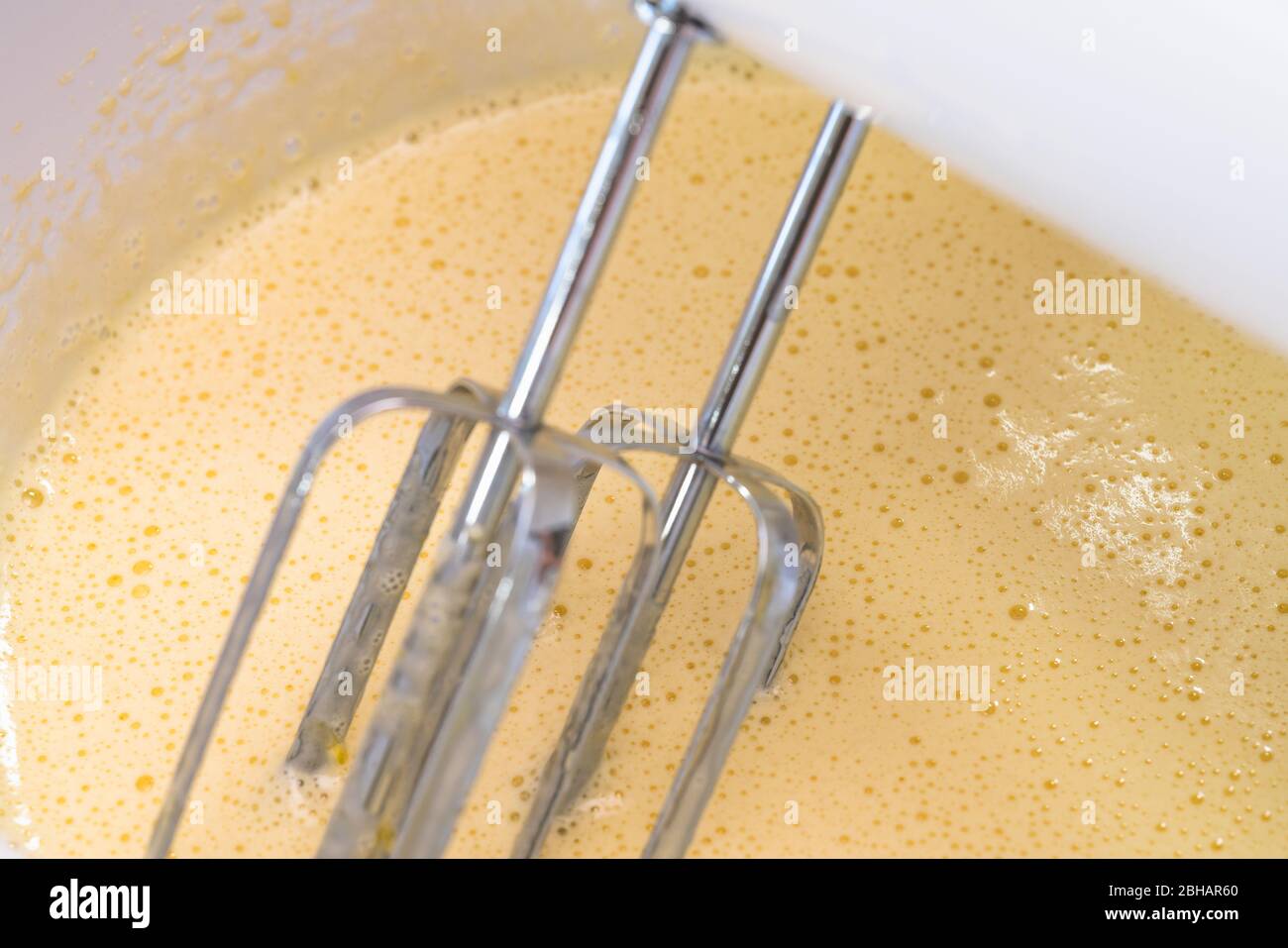 Mixing biscuit dough with an electic mixer. close up process. Cake batter making. Stock Photo