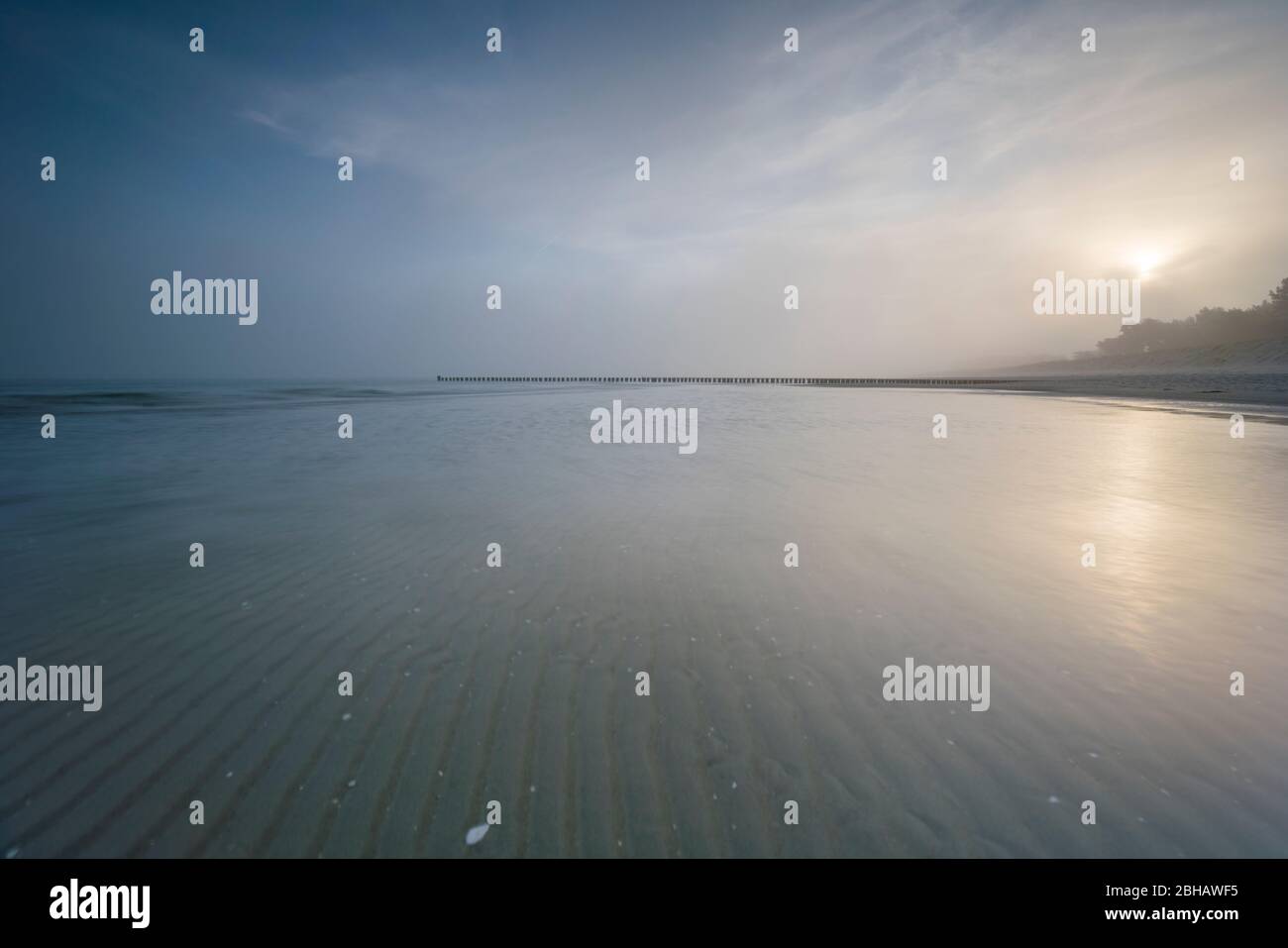 Sunrise in the winter by the sea with a falling mist of bright sun on a beautiful winter day Stock Photo