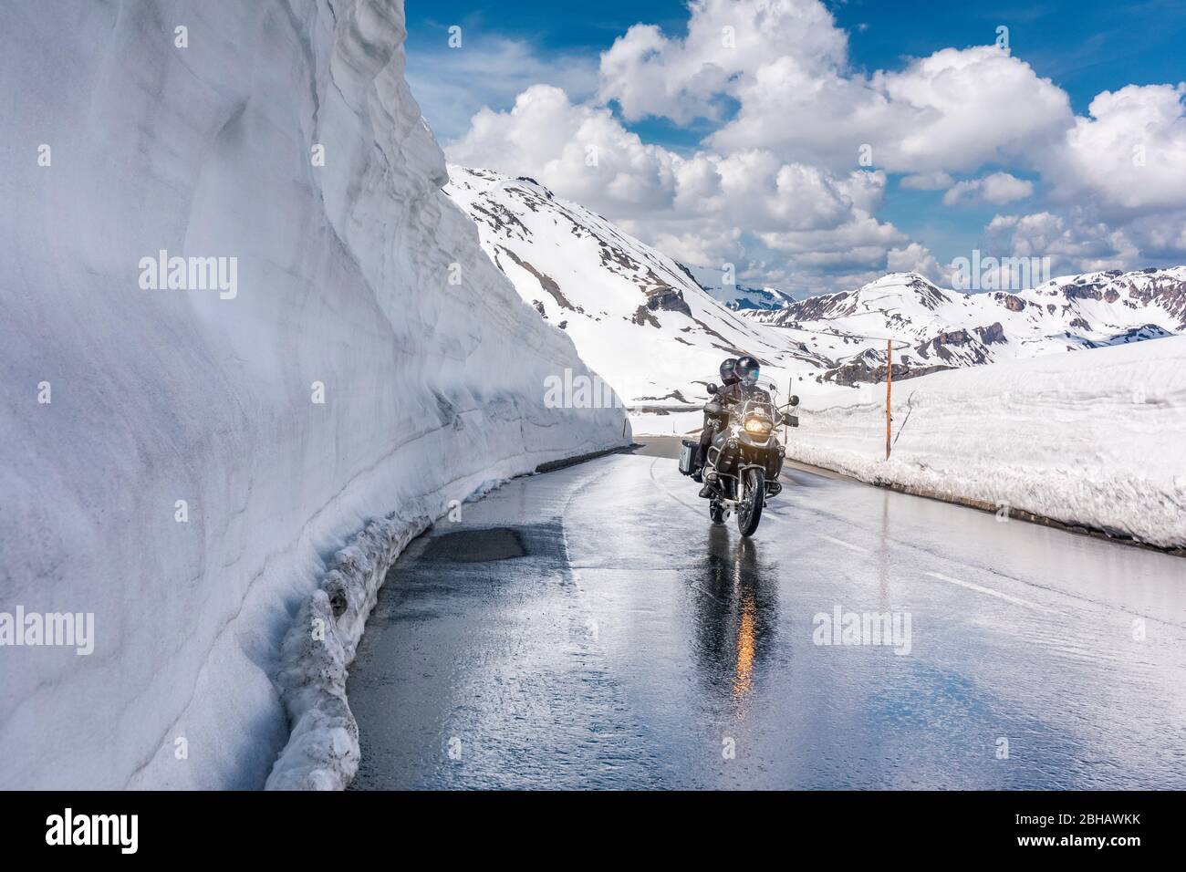 Motorbike near the Hochtor pass with very high snow on the sides of the wet road, Grossglockner High Alpine Mountain Road, Hohe Tauern National Park, Salzburg, Austria, Europe Stock Photo