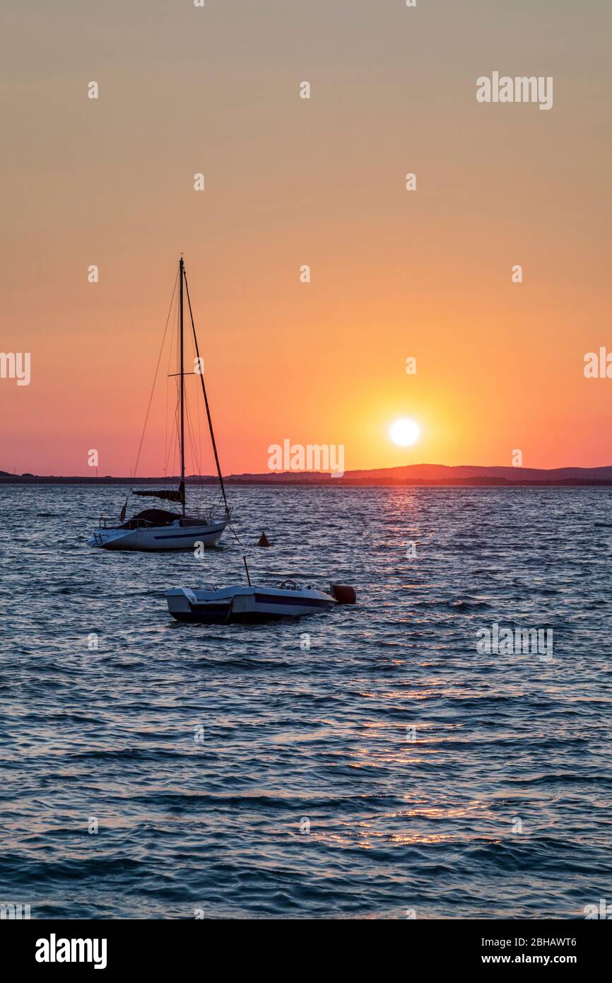 small boat moored in front of the beach of vrsi mulo at sunset, vrsi, zadar county, dalmatia, croatia Stock Photo
