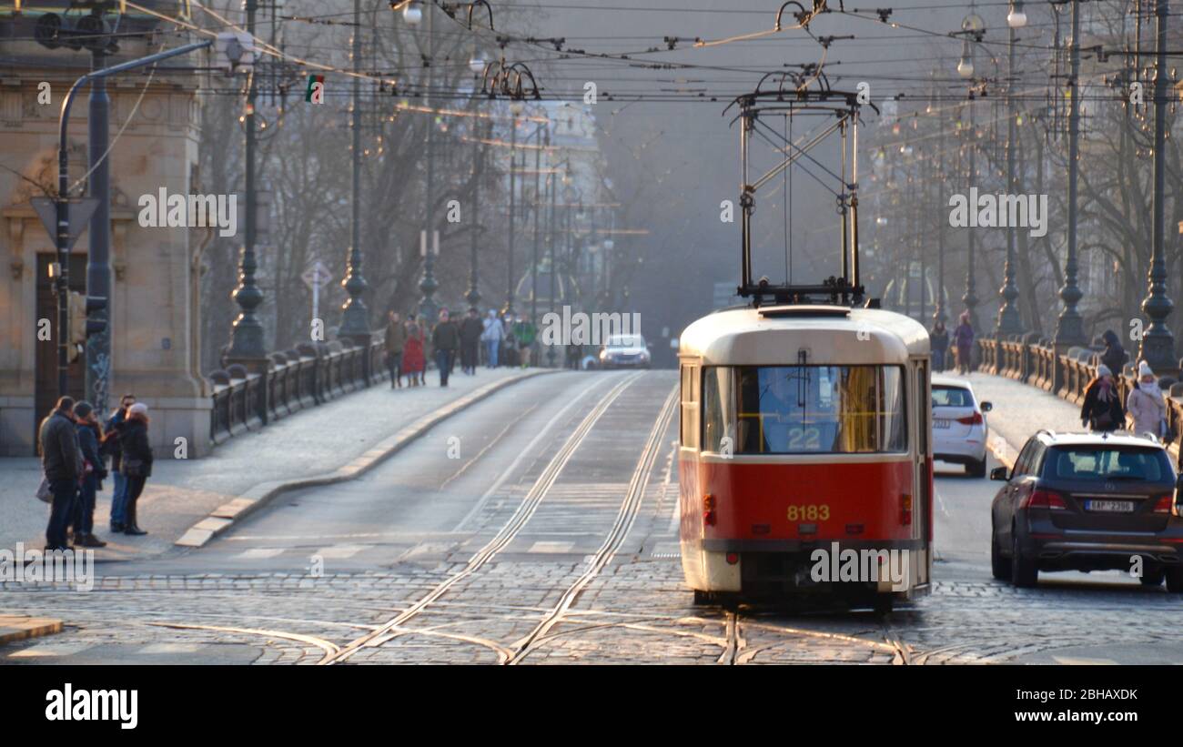 Electric red tram on a bridge over the Vltava river in Prague on a frigid cold winter day Stock Photo