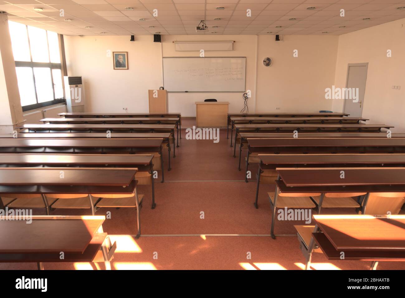 Shot of empty highschool classroom due to measures taken regarding global pandemic covid 19 with black board on sight Stock Photo