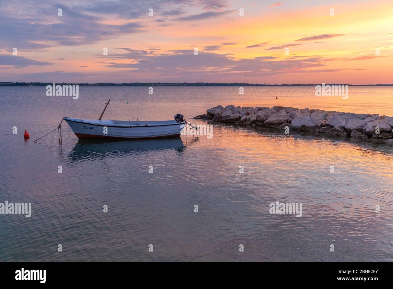 lonely boat moored on the beach of vrsi mulo at sunset, vrsi, zadar county, dalmatia, croatia Stock Photo