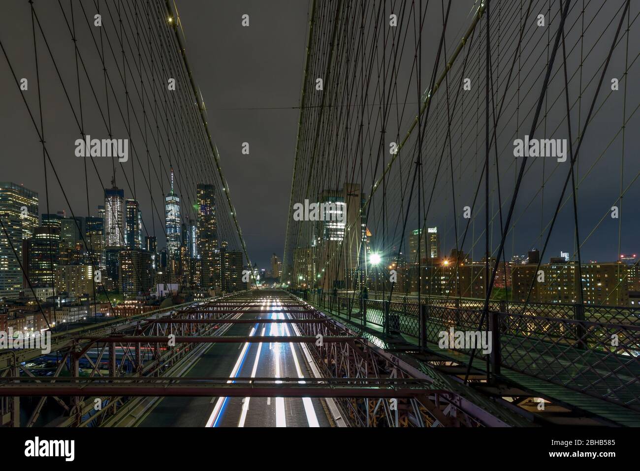 View over the Brooklyn Bridge At night to the illuminated skyscrapers in Manhattan Stock Photo