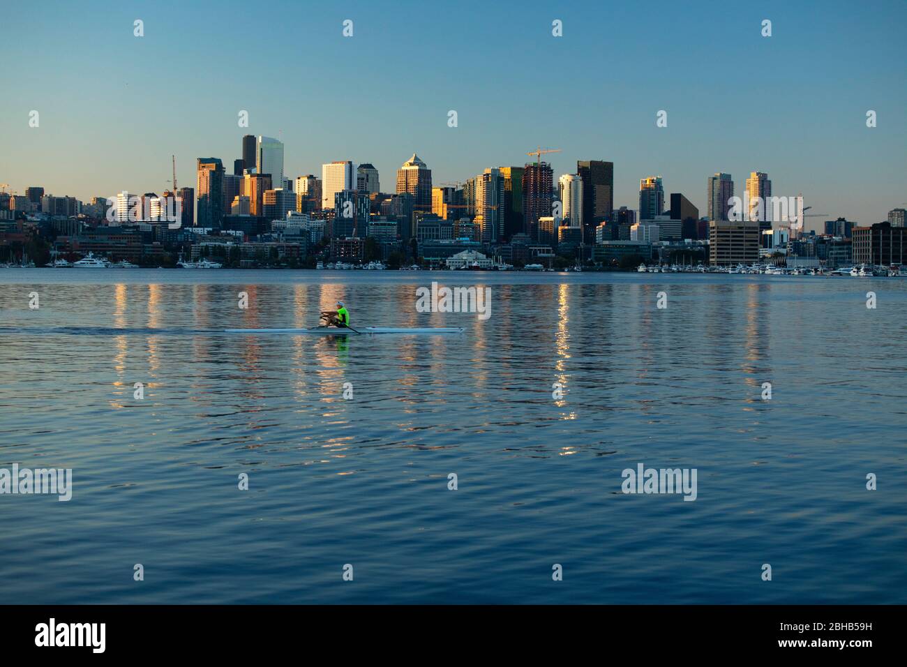 Person kayaking at sunset with city skyline in background, Seattle, Washington, USA Stock Photo