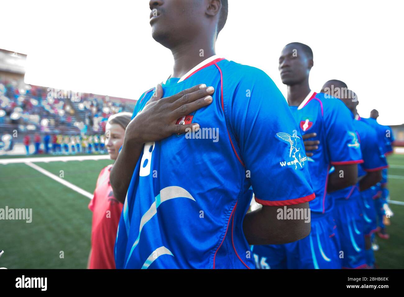 Austin, Texas USA, April 28, 2010: Members of the Haitian national soccer team place their hands over their heart as their national anthem plays before an exhibition match with the Austin Aztek professional soccer team. The Haitians' Port au Prince facility was decimated by the January 12th earthquake and 32 team members were killed. The surviving team members accepted an offer to train for two weeks in Texas and will travel to Argentina next week for South American matchups.  ©Bob Daemmrich Stock Photo
