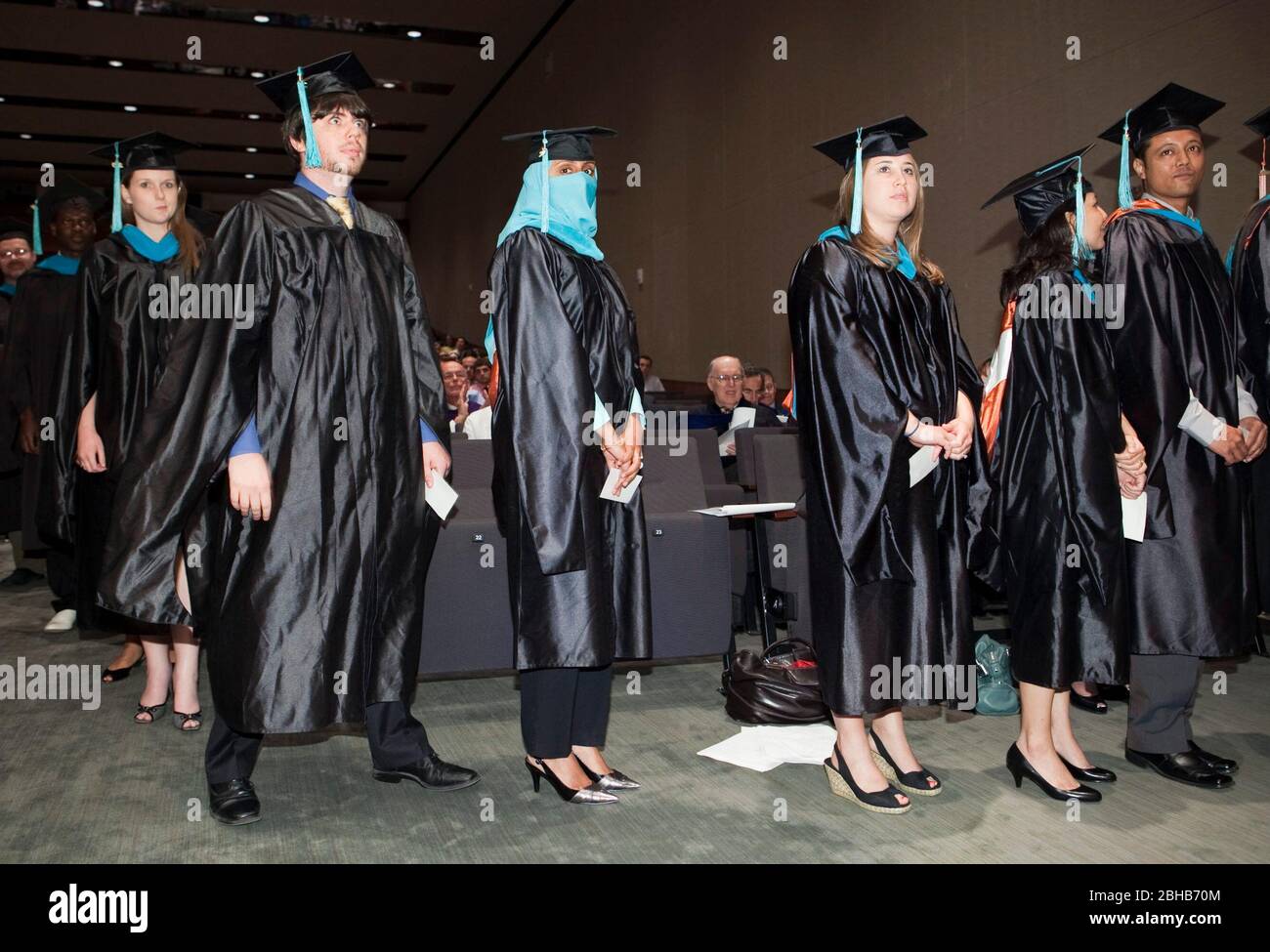 Austin, Texas USA, May 22, 2009: Graduation ceremony at the Lyndon Baines Johnson (LBJ) School of Public Affairs. Approximately 108 students received their Masters or PhD degrees in public policy studies through the school at the University of Texas at Austin. A female Muslim student wearing a niqab waits in line to receive her diploma onstage. ©Bob Daemmrich Stock Photo