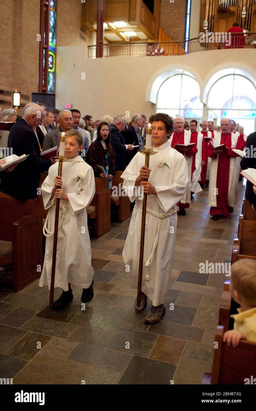 Austin, Texas USA, April 4 2010: Teenage alter boys wearing white albs and carrying candles lead the procession into the sanctuary for Easter Sunday service at Saint Martin's Lutheran Church. ©Bob Daemmrich Stock Photo