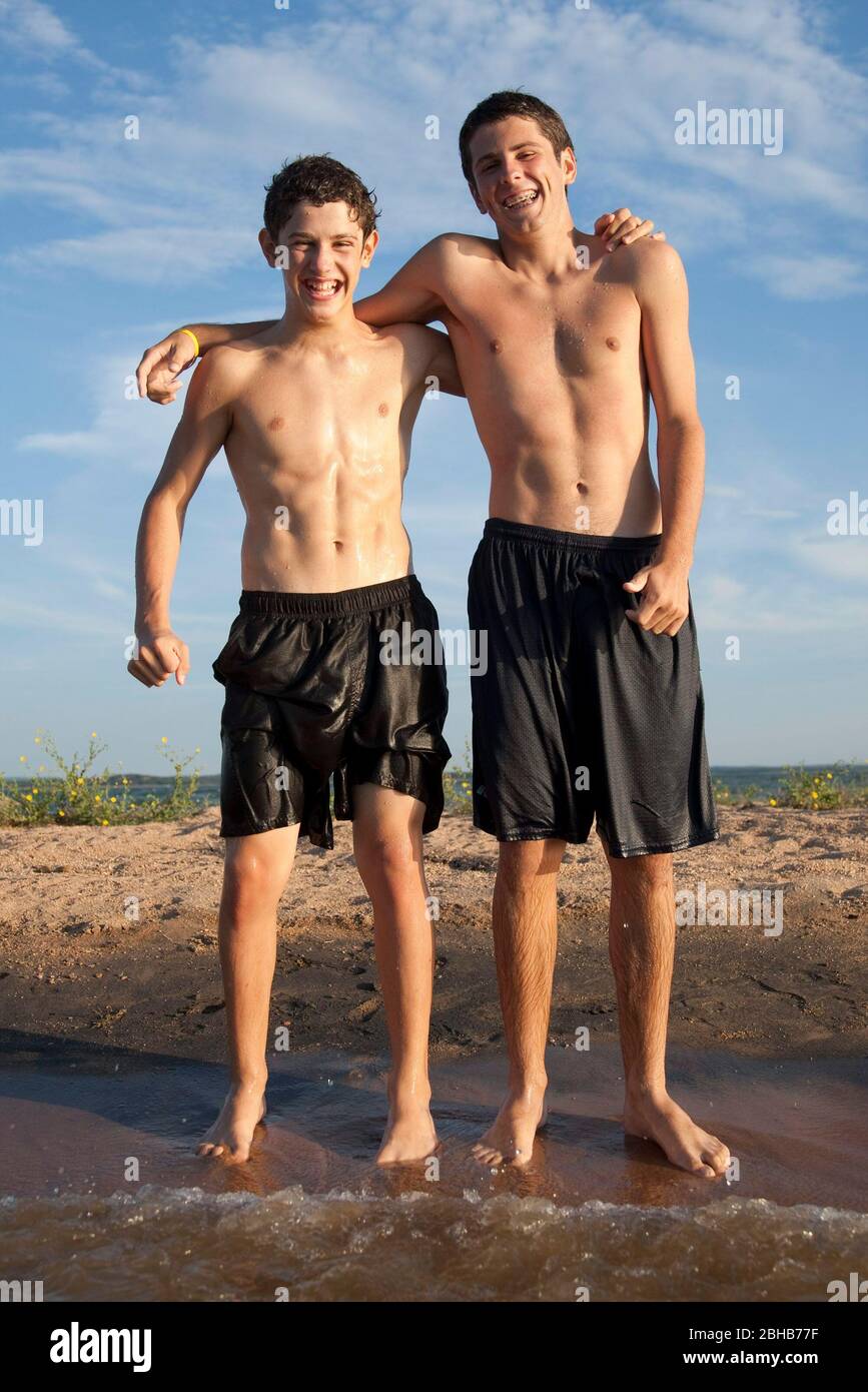 Burnet County Texas USA, August 7 2010: 13-year-old and 16-year-old brothers pose in shallow water off Shaw Island on Lake Buchanan in the summertime. ©Bob Daemmrich Stock Photo