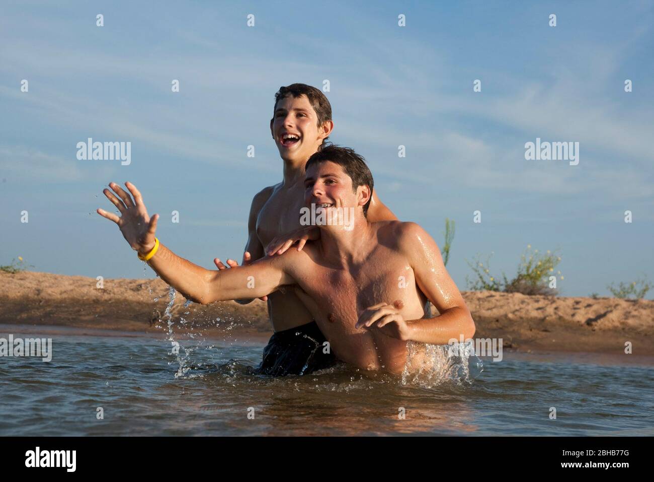 Burnet County Texas USA, August 7 2010: 13-year-old and 16-year-old brothers horse around together in shallow water off Shaw Island on Lake Buchanan in the summertime. ©Bob Daemmrich Stock Photo
