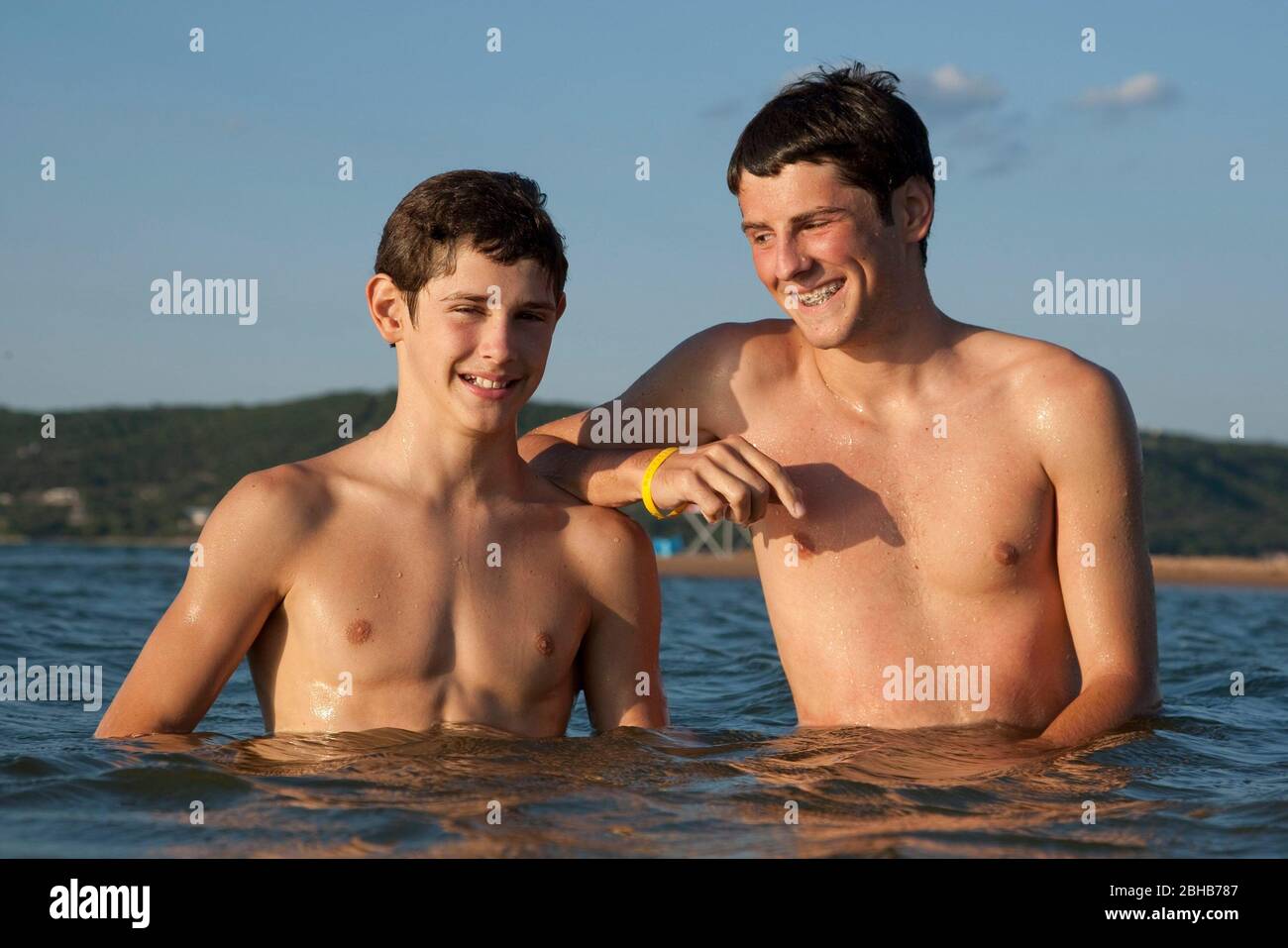 Burnet County Texas USA, August 7 2010: 13-year-old and 16-year-old brothers pose in shallow water off Shaw Island on Lake Buchanan in the summertime. ©Bob Daemmrich Stock Photo